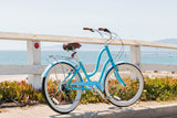 Blue bicycle parked by a wooden railing with a scenic ocean view in the background.